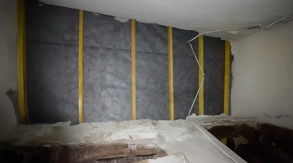 Chantier de rénovation intérieure en cours, murs partiellement démolis avec cloisons sèches arrachées