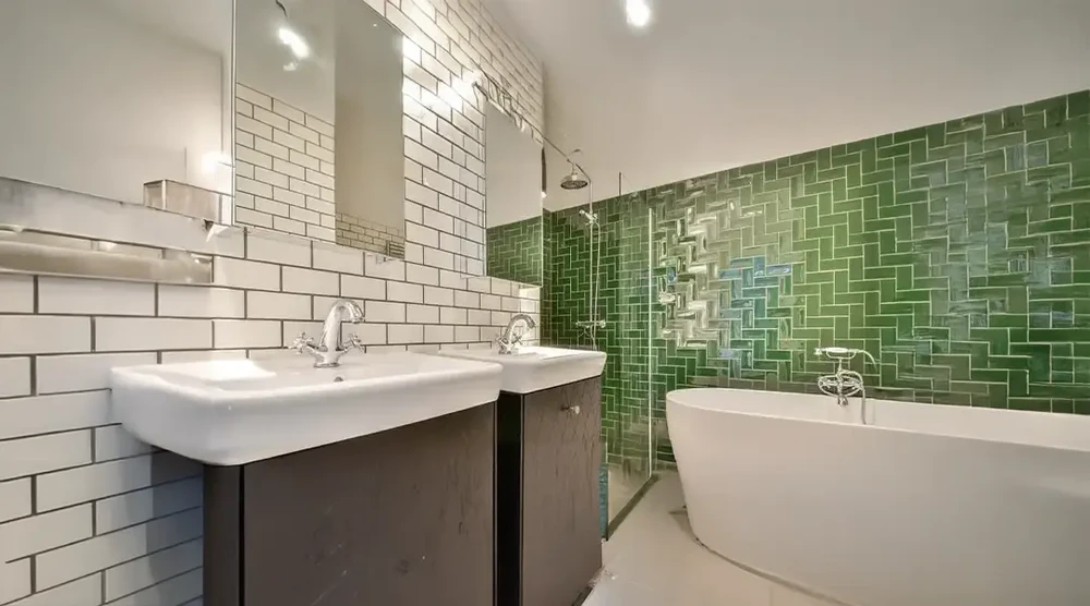 Salle de bain moderne avec double vasque suspendue sur meuble anthracite, baignoire îlot blanche et douche à l'italienne