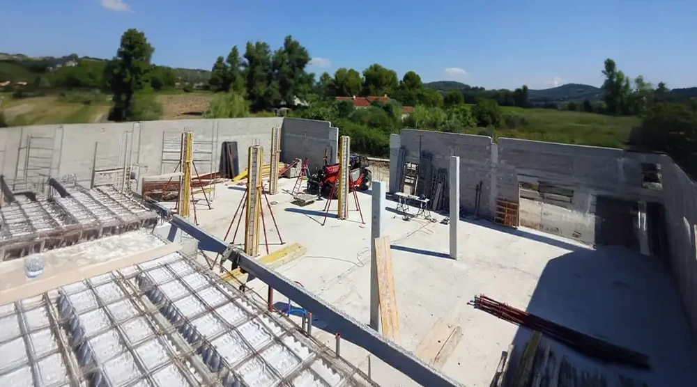 Chantier de construction extérieur avec ouvriers travaillant sur une structure en béton armé