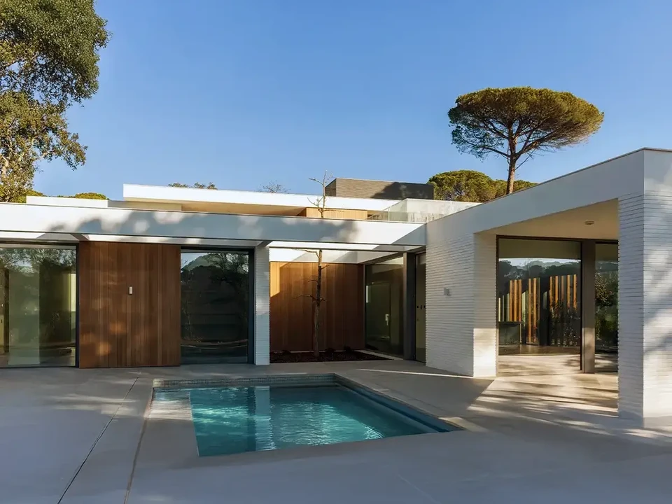 Chantier de construction résidentielle en cours avec ouvriers travaillant sur structure mixte béton et bois