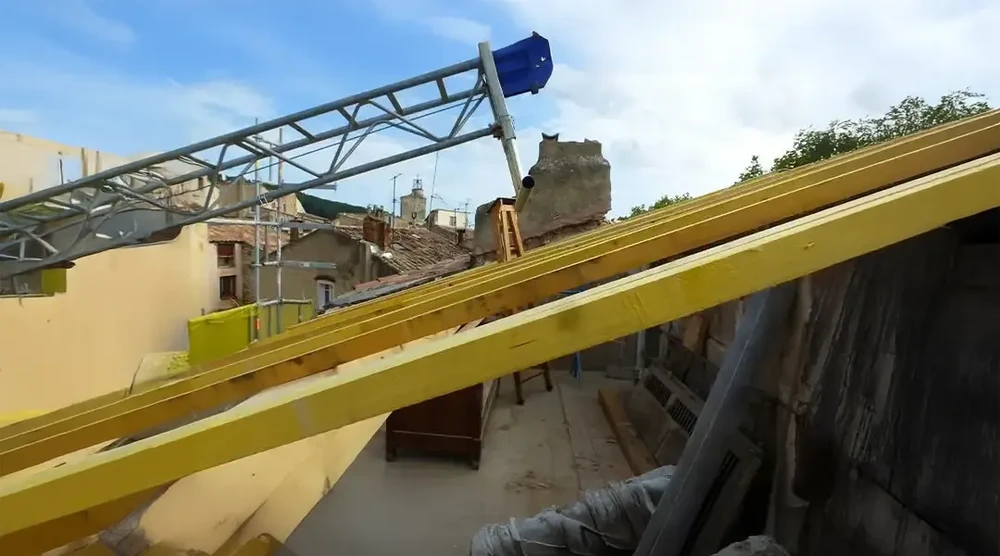 Piscine extérieure rectangulaire avec margelles en pierre naturelle, entourée d'une terrasse en lames de bois exotique
