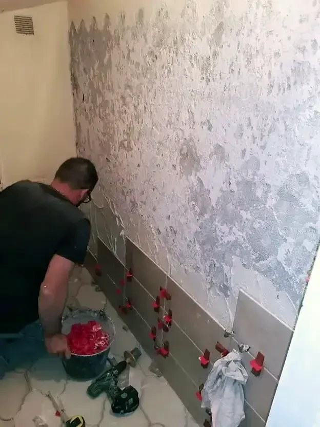 Piscine extérieure en cours de finition avec margelles en pierre claire et carrelage beige posé autour du bassin