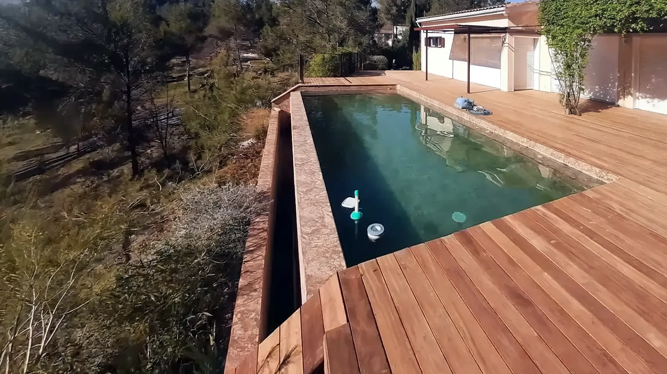 Int&eacute;rieur r&eacute;sidentiel avec chemin&eacute;e &agrave; foyer ferm&eacute; en fonctionnement, escalier en travertin, mur en pierres naturelles apparentes et poutres en bois massif