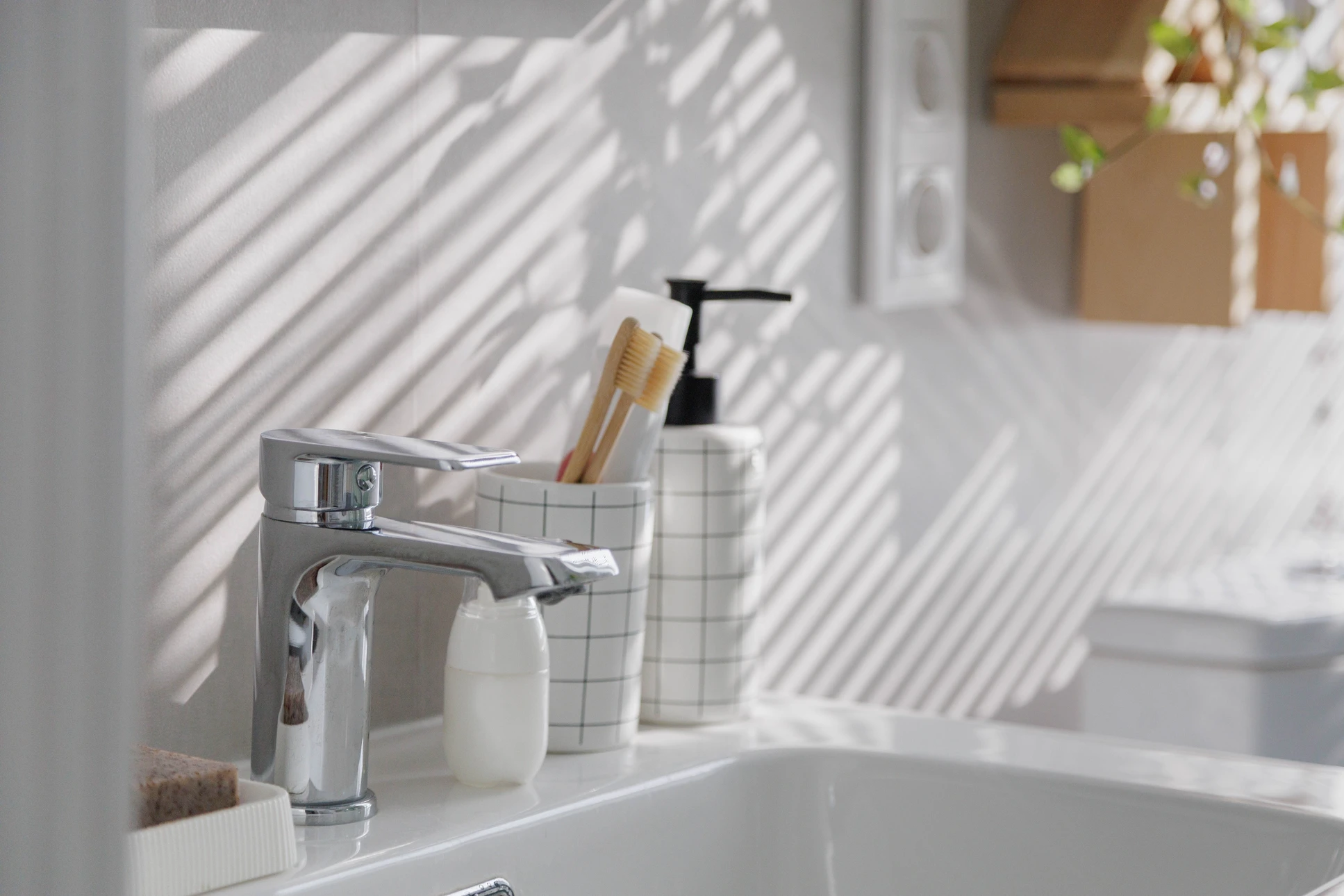 Salle de bain en cours de r&eacute;novation avec toilettes blanches install&eacute;es et robinetterie chrom&eacute;e en attente de raccordement